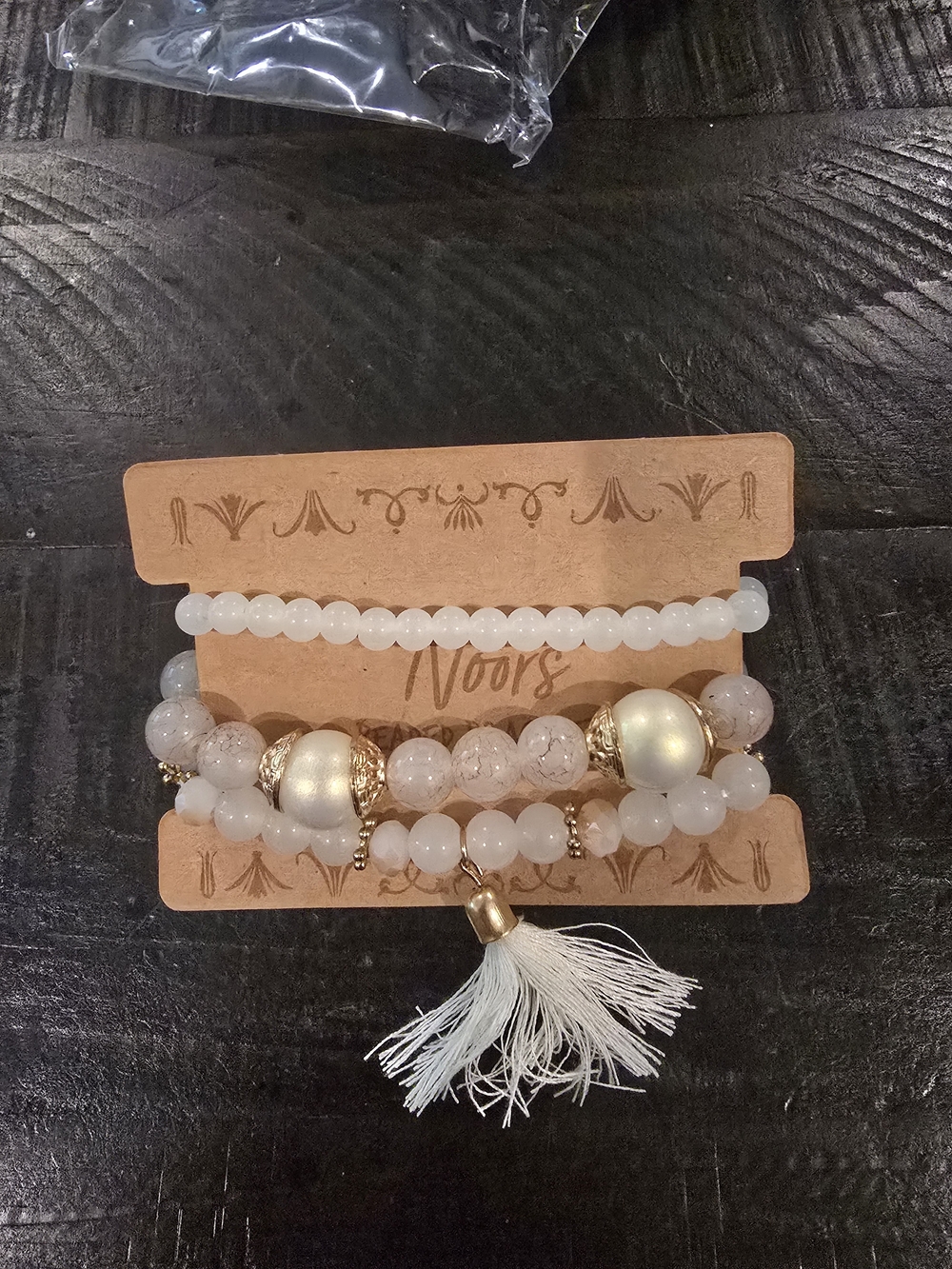 White Beaded Bracelet Stack with Gold Accents and Tassel
